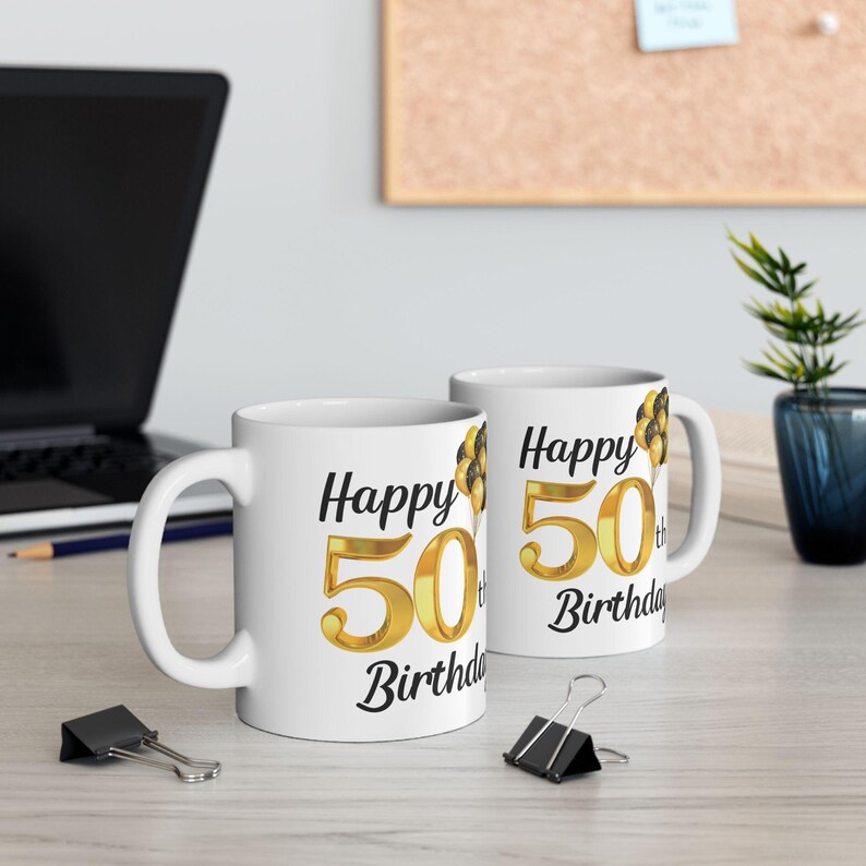 May include: Two white ceramic mugs with black text and gold numbers. The mugs say "Happy 50th Birthday".