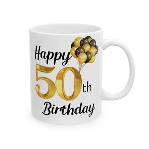 May include: White ceramic mug with a black and gold design. The mug features the text "Happy 50th Birthday" with gold balloons.