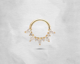 May include: A gold hoop earring with a circle of clear cubic zirconia stones. The stones are set in a pave setting and are arranged in a circular pattern around the hoop.