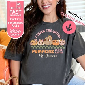 May include: A dark gray t-shirt with a graphic of pumpkins and the text "I teach the cutest pumpkins in the patch! Ms. Donovan".