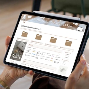 May include: A black tablet displaying the "Ultimate Business Planner" interface, held by a person. The screen shows project management tools and the text "Start Today". A stylus is attached to the tablet.