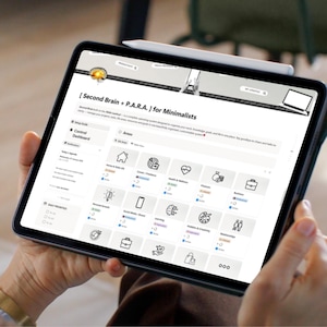 May include: A black tablet displaying a digital interface with the text "[Second Brain + P.A.R.A.] for Minimalists." The screen shows various icons and categories, including "Areas," "Home & Daily Life," and "Career/Freelance." A stylus rests on the tablet's edge.