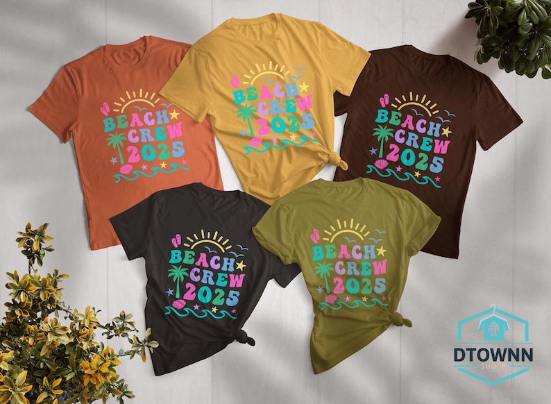 Puede incluir: Cinco camisetas de colores variados, naranja, amarillo, marr&oacute;n, negro y verde oliva, con el texto "BEACH CREW 2025". El dise&ntilde;o incluye un sol, una palmera y olas, con tem&aacute;tica playera.