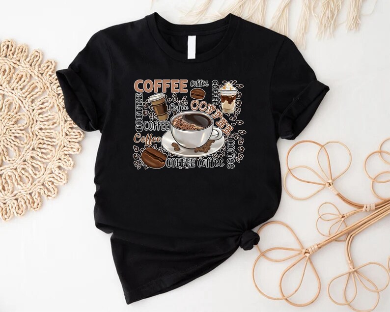 May include: Black t-shirt featuring a graphic design of coffee cups, coffee beans, and the word "Coffee" repeated in various fonts and sizes.