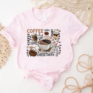 May include: Pink t-shirt featuring a coffee cup, coffee beans, and the word "Coffee" repeated several times.