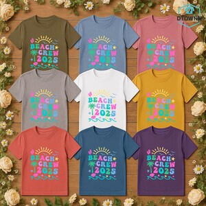 Puede incluir: Nueve camisetas coloridas con el texto "BEACH CREW 2025" en una fuente juguetona. El dise&ntilde;o incluye un sol, una palmera y olas. Las camisetas son de varios colores, como verde oliva, azul, rosa y blanco.