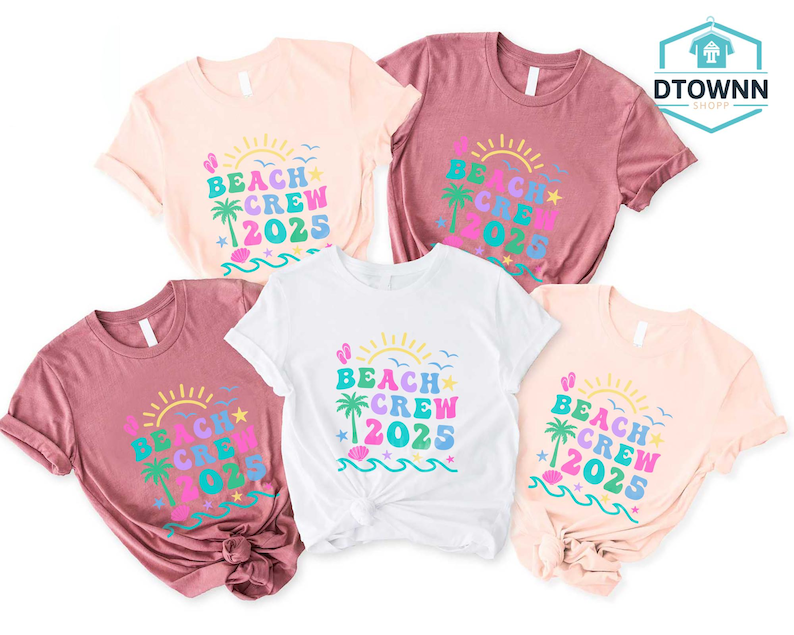 Puede incluir: Cinco camisetas en varios colores, incluyendo blanco, rosa y malva. Cada camiseta presenta el texto "BEACH CREW 2025" en un dise&ntilde;o colorido con un sol, una palmera y olas. Las camisetas son de manga corta.
