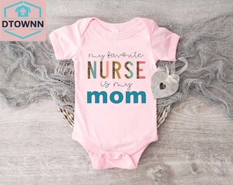May include: Pink baby onesie with the text "My favorite nurse is my mom" in colorful letters.