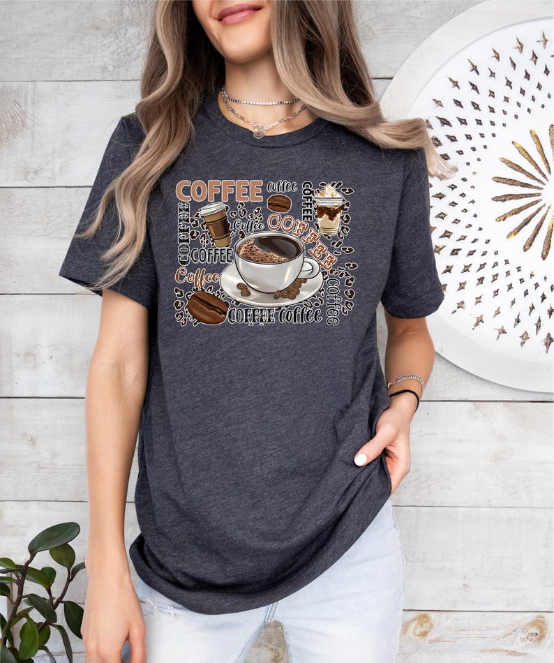 May include: A dark grey t-shirt featuring a graphic design of coffee cups, coffee beans, and the word "coffee" repeated in various fonts and sizes.