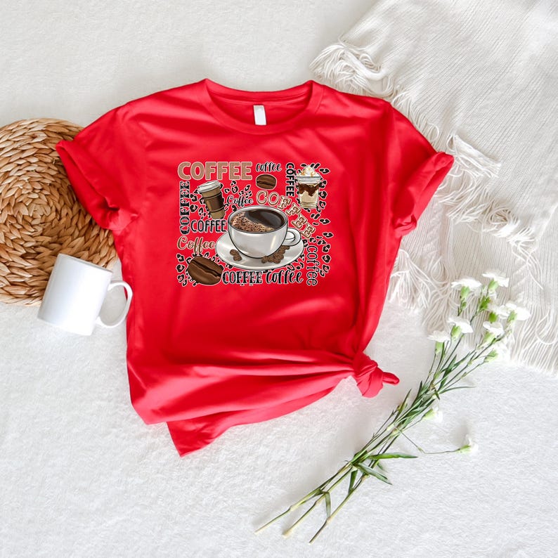 May include: Red t-shirt featuring a graphic design of coffee cups and coffee beans. The design incorporates the word "coffee" repeated in various sizes and styles.