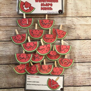 May include: A watermelon-themed educational game with the text "Watermelon Shape Match." The game features watermelon slice cutouts with various shapes, designed for matching activities. The game includes a clear pouch and wooden clothespins.