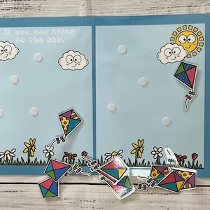 May include: A blue folder with a white background and colorful kites. The folder has the text "I can add kites to the sky." and a sun and cloud with a smiley face. The folder is labeled "Go Fly a Kite" and "Encores Learning."