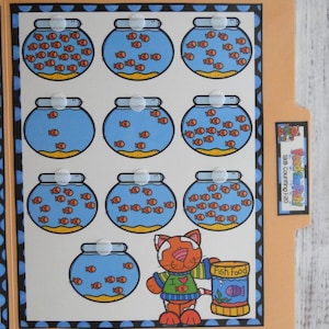 May include: A tan file folder educational activity titled Feed the Fish! Skills Counting 1-20. The interior features ten illustrations of blue fishbowls with orange fish and a cartoon cat holding a yellow container labelled Fish Food.