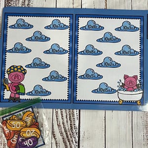 May include: A blue educational math game featuring multiplication problems with a pig theme. The game includes a booklet with cloud-shaped equations and a bag of number tokens. The booklet has the text "PIGGY PRODUCTS".