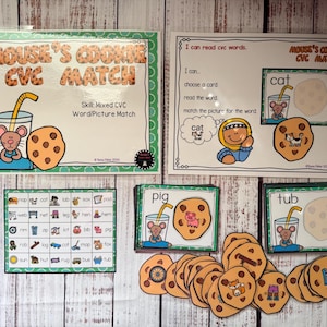 May include: Educational game featuring "Mouse's Cookie CVC Match" with word and picture matching. Includes cards with illustrations of a mouse, cookies, and glasses of milk. The game is designed for early literacy.