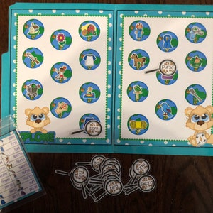 May include: A blue folder with a white background and colorful circles. The folder has a white label with the word "EXPLORE" on it. The folder contains a set of colorful cards with pictures of various objects, such as a house, a flower, a sword, a horse, a purse, a bird, and a shirt. The cards are arranged in a grid pattern. There are also a set of magnifying glasses with different words on them, such as "farm", "first", "sword", and "bird".