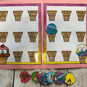 May include: A pink folder with a game for kids to match ice cream cones with words that rhyme. The words are printed on the cones and include "cake", "cape", "game", "mane", "wave", "shake", "date", "tape", "gate", "same", "lake", "cave", "cane", "rake", "wake", and "bake".