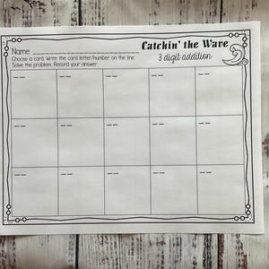 Op de afbeelding: Een zwart-witte printbare werkblaadje met de titel "Catchin' the Wave 3 digit addition". De werkblaadje heeft een ruimte voor een naam bovenaan en een raster van 15 vakjes om optelsommen op te lossen.