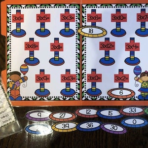 May include: A colorful multiplication learning game with a file folder design. The game features multiplication problems like 3x1= and 3x5=, with answer cards and an answer key. The game is designed for educational purposes.