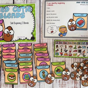 May include: An educational activity set titled Seed Cutie Blends featuring a large instruction card, a reference chart, and multiple small cards with fill-in-the-blank words. The cards feature cartoon seeds with faces and various colorful illustrations.