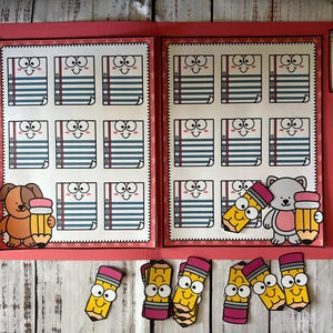 May include: A pink folder with two pages featuring smiling notebook illustrations. A cartoon dog and bear hold pencils. Additional pencil cutouts are scattered below. The folder has the text "Powell & Dragon Designs, Errorless Learning".