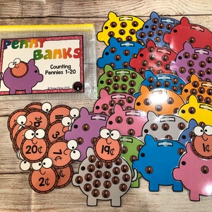 May include: A set of colorful piggy banks with different amounts of pennies inside. Each piggy bank has a number on it, from 1 to 20. The set also includes a set of penny coins with different amounts printed on them. The set is labeled "Penny Banks Counting Pennies 1-20".