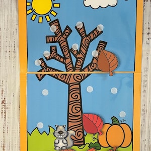 May include: A colorful felt board activity for kids featuring a tree with leaves falling off, a squirrel, a pumpkin, and a sun. The text "Falling Leaves! Errorless Learning" is at the top of the board.