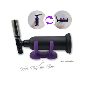 May include: Purple magnetic stand for a torch with a black base and a silver nozzle. The stand has two purple prongs and a magnetic base. "Torch not included." is written in the image.