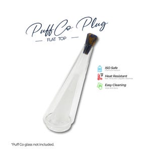 May include: A clear glass Puff Co Plug with a flat top design. The plug has a conical shape with a dark brown and black stopper. The image includes text indicating it is ISO safe, heat resistant, and easy to clean.