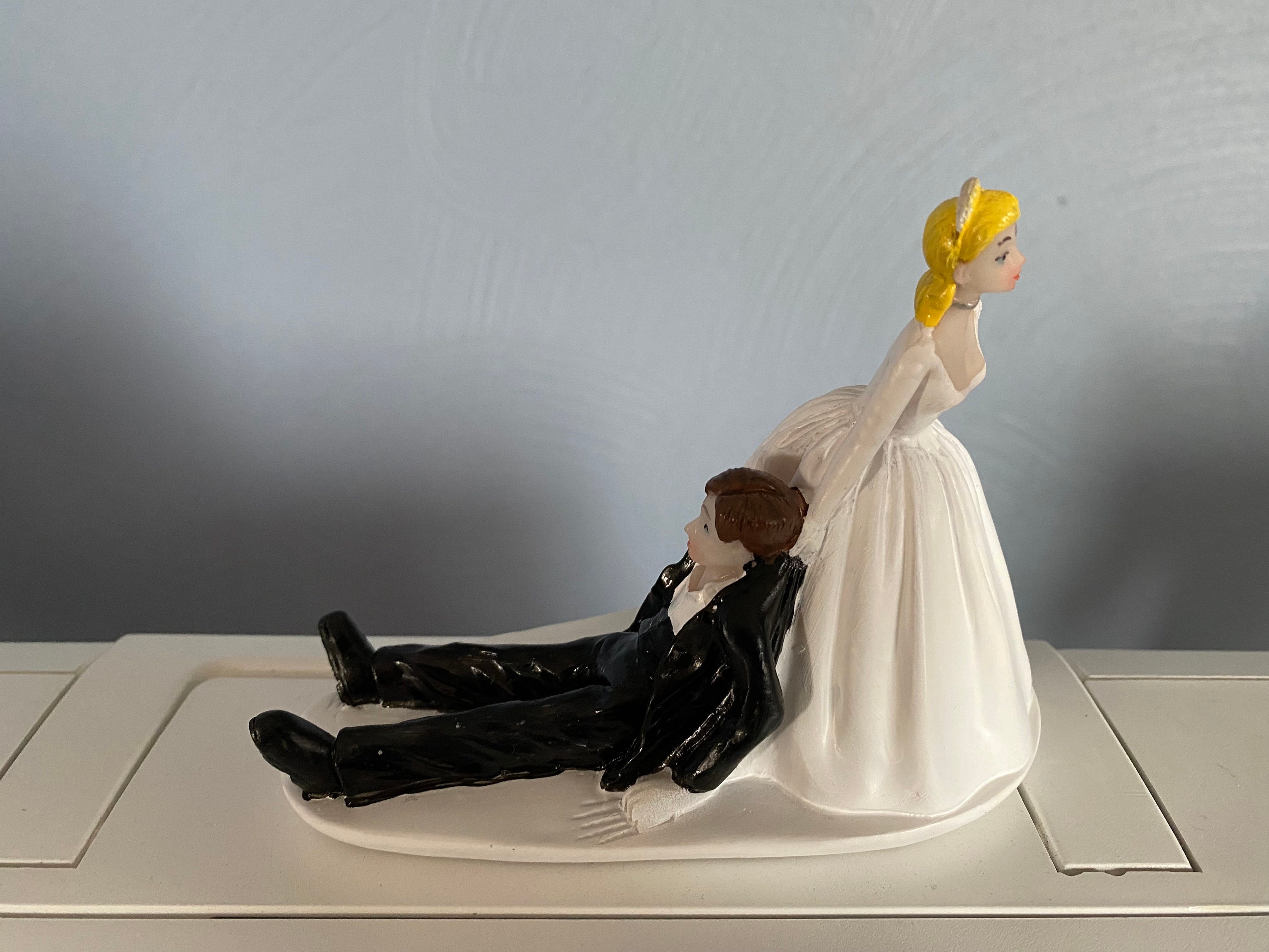 Wedding cake topper woman dragging man | Honestweddingadvice.com Wedding cake topper woman dragging man | Honestweddingadvice.com
