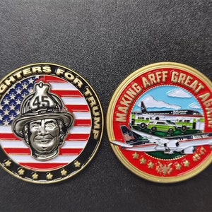 May include: Two gold-colored round coins with red, white, and blue designs. The first coin features a firefighter with the text "Firefighters for Trump". The second coin features an airplane with the text "Making Arff Great Again".