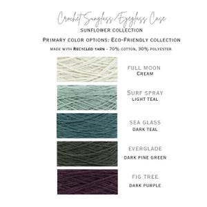 May include: Five yarn samples in different colors, from top to bottom: cream, light teal, dark teal, dark pine green, and dark purple. The yarn is made from 70% cotton and 30% polyester. The text "Full Moon", "Surf Spray", "Sea Glass", "Everglade", and "Fig Tree" are written below each yarn sample, along with the color name.