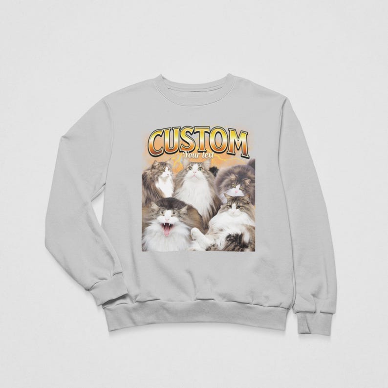 May include: A light gray crewneck sweatshirt featuring a graphic print of five long-haired cats. Above the cats, the word CUSTOM is printed in a bold, yellow-to-orange gradient font, with the words Your text printed in smaller white letters.