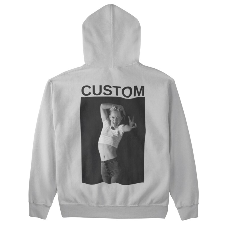 May include: White hoodie with a hood and a black and white image on the back. The image features a person making a peace sign and the word "CUSTOM" above the image.