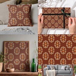 Op de afbeelding: Een decoratief patroon in bruin, crème en oranje siert een kussen, cadeaupapier, ingelijste kunst en een muur. Het herhalende ontwerp heeft een symmetrisch, bloemachtig motief. Het thema is woondecoratie en cadeauartikelen.