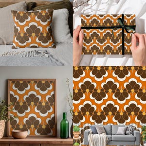 Puede incluir: Una colección de artículos de decoración para el hogar con un patrón floral repetido en tonos marrón, blanco y naranja. Los artículos incluyen un cojín, una impresión enmarcada y papel de regalo con una cinta negra.