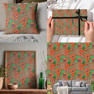 Op de afbeelding: Een verzameling woondecoratie-artikelen met een bloemenpatroon in oranje, groen en blauw op een bruine achtergrond. De items omvatten een sierkussen, ingelijste kunstwerken en cadeaupapier met een zwart lint.
