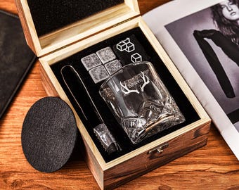 May include: A wooden box with a glass whiskey tumbler, ice cubes, and a metal tongs. The tumbler is engraved with the name "Shawn" and a pair of antlers.