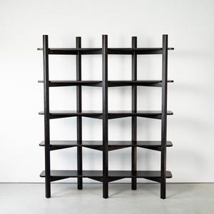 Könnte beinhalten: Ein dunkelbraunes Bücherregal aus Holz mit mehreren Regalen. Das Bücherregal hat ein leiterartiges Design mit vertikalen Stützen und horizontalen Regalen. Die Regale sind gleichmäßig verteilt und scheinen aus massivem Holz zu bestehen. Das Bücherregal steht vor einer weißen Wand.