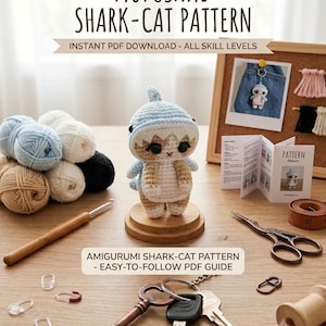 Może przedstawiać: Szydełkowa figurka amigurumi w kształcie kota-rekina w kolorze jasnoniebieskim i beżowym, stojąca na drewnianej podstawie. Obraz zawiera tekst MOFUSAND SHARK-CAT PATTERN, INSTANT PDF DOWNLOAD - ALL SKILL LEVELS oraz AMIGURUMI SHARK-CAT PATTERN - EASY-TO-FOLLOW PDF GUIDE.