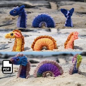 Könnte beinhalten: Ein Häkelmuster-PDF zum Herstellen von drei verschiedenen Amigurumi-Meeresdrachenspielzeugen. Die Meeresdrachen sind blau, orange und lila mit einem Regenbogenmuster. Das PDF steht zum Download bereit.
