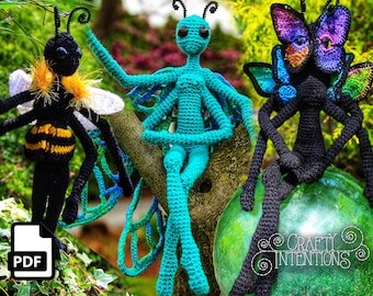 May include: Three crocheted amigurumi toys: a bee, a dragonfly, and a butterfly. The bee is black and yellow with white wings. The dragonfly is teal blue with green wings. The butterfly is black with iridescent purple and blue wings. The toys are sitting on a tree branch and a glass orb. The image includes the text "Crafty Intentions".