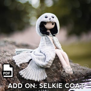 May include: A crochet pattern for a gray hooded coat with a seal head design. The pattern is available as a PDF download. The text "ADD ON: SELKIE COAT" is at the bottom of the image.