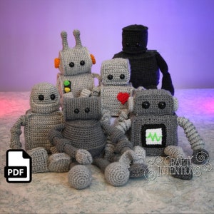 Puede incluir: Un conjunto de siete juguetes de robot amigurumi de crochet. Los robots son todos grises con diferentes acentos de color. Un robot tiene un cuerpo negro, uno tiene un corazón rojo, uno tiene una luz verde y uno tiene un símbolo verde de ECG. Los robots están todos sentados en una superficie gris. La imagen incluye el texto "CRAFTY INTENTIONS".