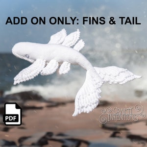 以下が含まれることがあります： 白いかぎ針編みのクジラ、ひれと尾付き。「ADD ON ONLY: FINS & TAIL」の文字が画像上部にあります。PDFアイコンが左下にあります。Crafty Intentionsのロゴが右下にあります。