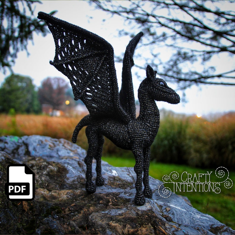 May include: Black crochet amigurumi of a winged horse, or hippogriff, standing on a rock. The crochet pattern is available as a PDF download.