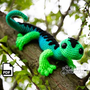 May include: Crochet pattern for a green and blue lizard with black markings. The pattern is available as a PDF download.