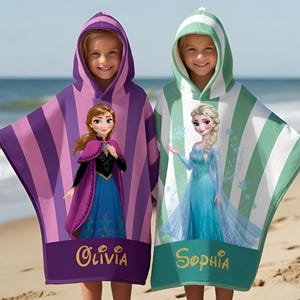 Puede incluir: Dos ponchos de playa con capucha para ni&ntilde;os. Uno es morado con rayas rosas y presenta a Anna, el otro es de rayas verdes y blancas con Elsa. Cada uno tiene un nombre impreso en la parte inferior: Olivia y Sophia.