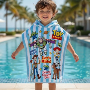 May include: A blue and white striped hooded towel featuring Toy Story characters. The towel has images of Buzz Lightyear, Woody, Jessie, and the Little Green Men. The words "Toy Story", "Space Ranger", "Let's Ride!", and "Deluxe Cowgirl Doll" are also printed on the towel.