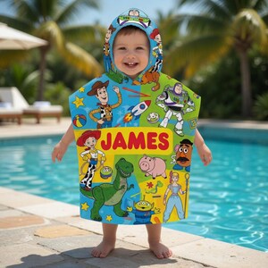 Puede incluir: Un ni&ntilde;o lleva una colorida toalla con capucha con personajes de la pel&iacute;cula Toy Story. La toalla es principalmente azul, verde y amarilla, con el nombre "JAMES" en letras rojas grandes. El fondo muestra una piscina y palmeras.
